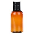 2 oz. Clarified Amber PET Cosmo Round Bottle with 20/410 Black Polypropylene Disc-Top Dispensing Cap
