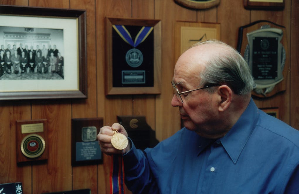 Stanley in his office holding a medal