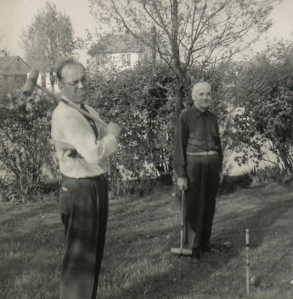 Stanley playing croquet with another man. Stanley is making a funny face at the camera