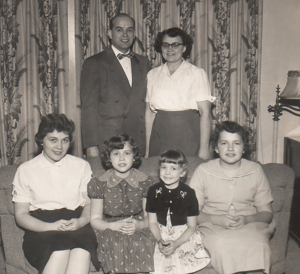 Stanley and his wife standing behind their four children seated on a couch