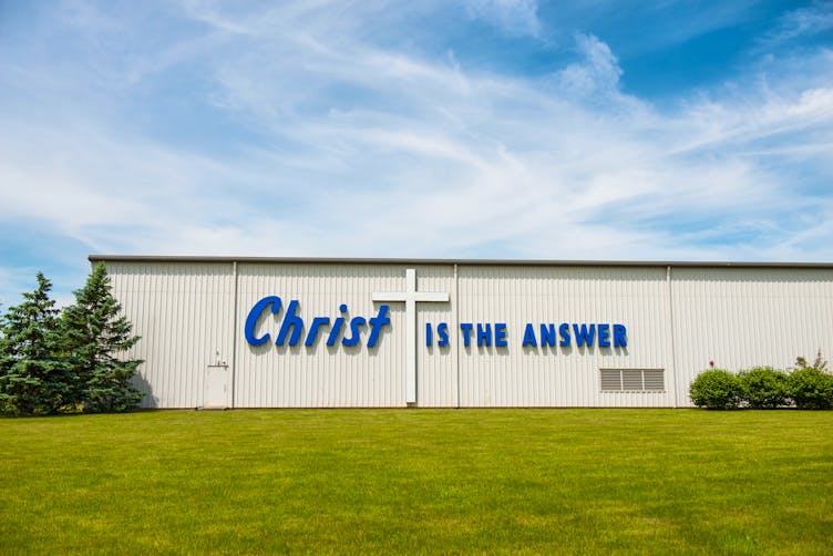 Text on the side of the U.S. Plastic building reads, 'Christ is the Answer'